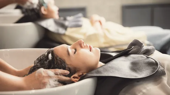 Stylist working with a client in a bright salon.