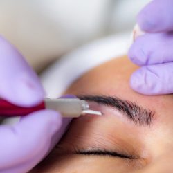 Beautician Microblading Eyebrows in Beauty Salon